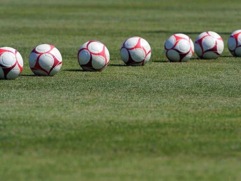 Soccer-balls-in-a-line-on-a-field Soccer-balls-in-a-line-on-a-field